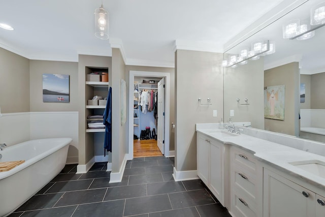 bathroom featuring vanity, a bathtub, ornamental molding, and built in shelves