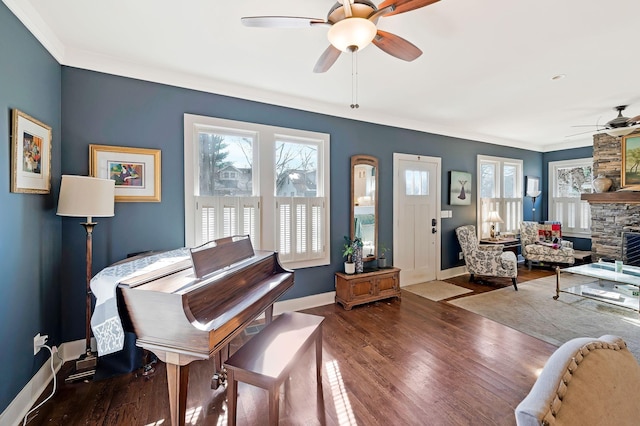 misc room featuring ceiling fan, a fireplace, crown molding, and hardwood / wood-style floors