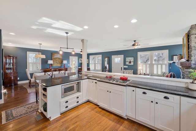 kitchen featuring decorative light fixtures, white cabinetry, stainless steel gas cooktop, and ceiling fan