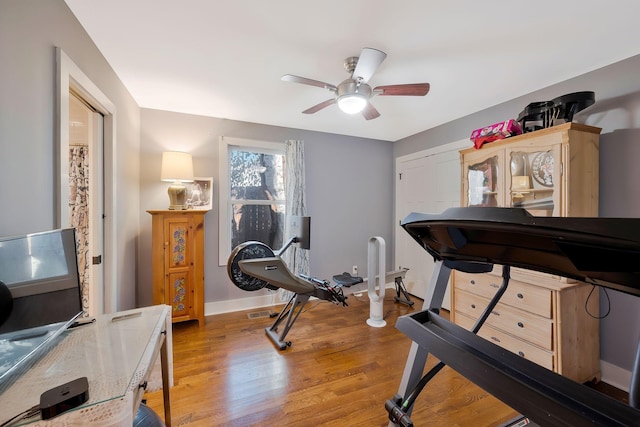 workout area with ceiling fan and hardwood / wood-style floors