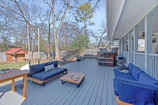 wooden deck with an outdoor living space and a storage unit