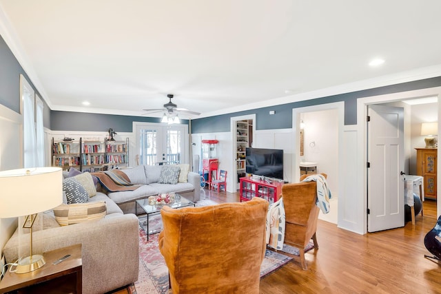 living room with light wood-type flooring, ceiling fan, crown molding, and french doors