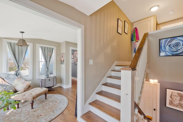 stairway with lofted ceiling and hardwood / wood-style flooring