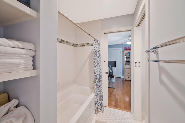 bathroom with ceiling fan and shower / bath combination with curtain