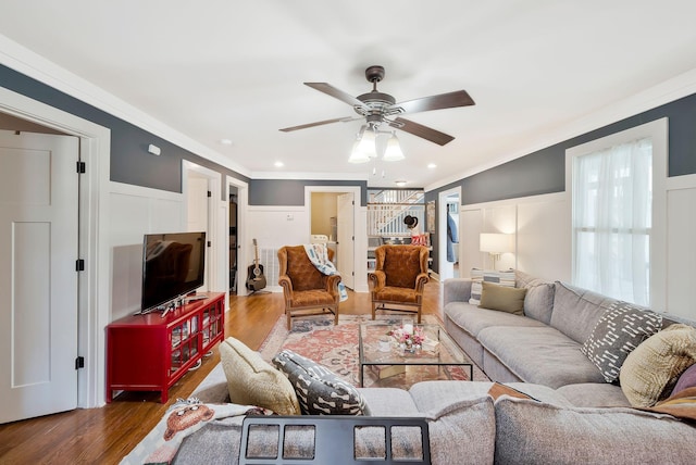 living room with ceiling fan, dark wood-type flooring, and ornamental molding