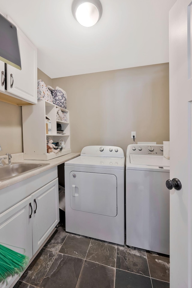 laundry room with washing machine and dryer, sink, and cabinets