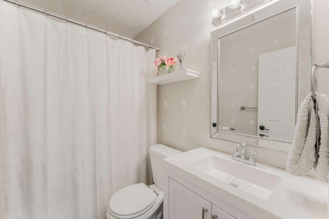 bathroom featuring vanity, a textured ceiling, and toilet