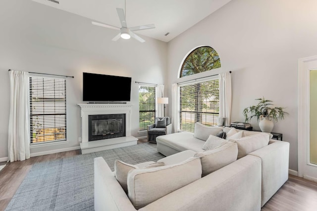 living room with light hardwood / wood-style floors, high vaulted ceiling, and ceiling fan