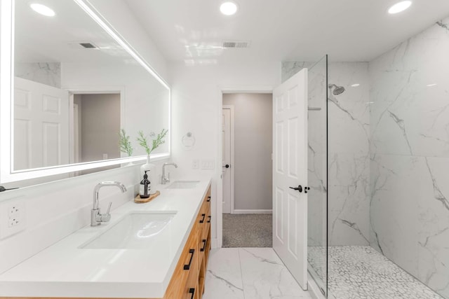 bathroom with tiled shower and vanity