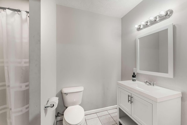 bathroom with tile patterned floors, vanity, a textured ceiling, and toilet