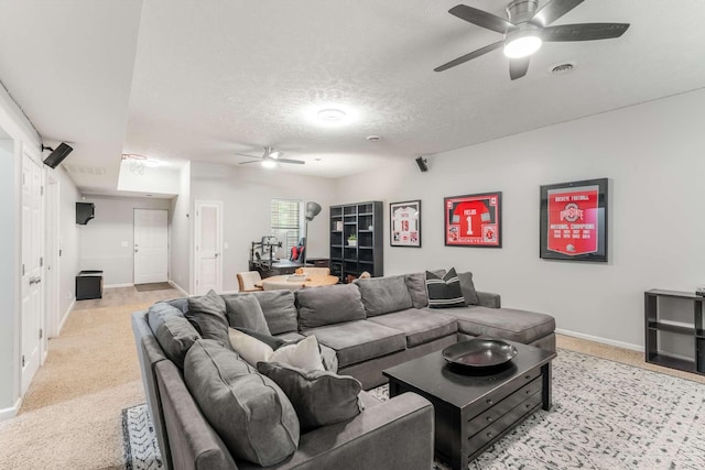 carpeted living room featuring ceiling fan and a textured ceiling