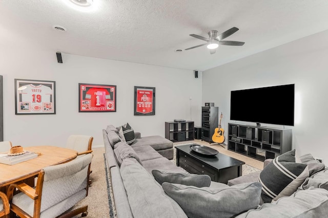 carpeted living room with ceiling fan and a textured ceiling