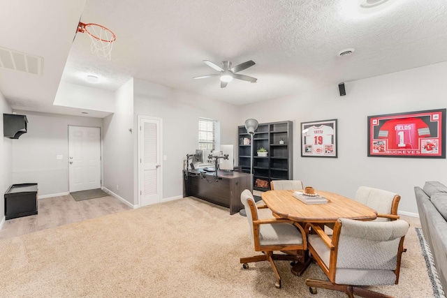 carpeted dining area featuring ceiling fan and a textured ceiling