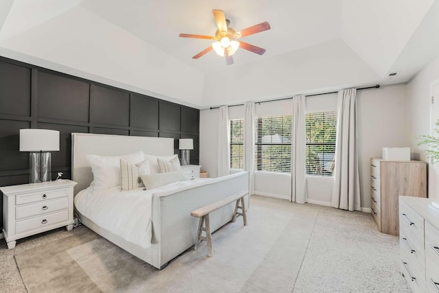 bedroom with ceiling fan and a tray ceiling