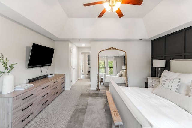 carpeted bedroom with a tray ceiling and ceiling fan