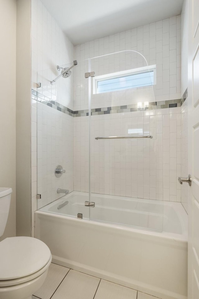 bathroom with toilet, tile patterned floors, and tiled shower / bath