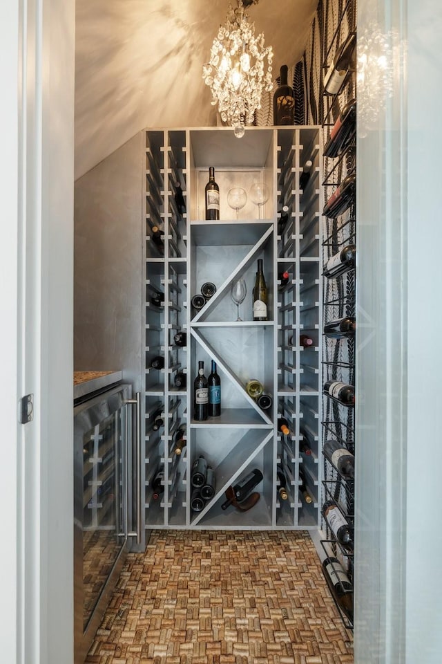 wine cellar with wine cooler and an inviting chandelier