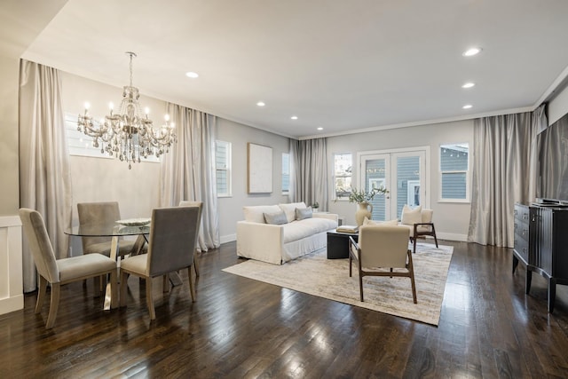 living room featuring an inviting chandelier, crown molding, and dark wood-type flooring