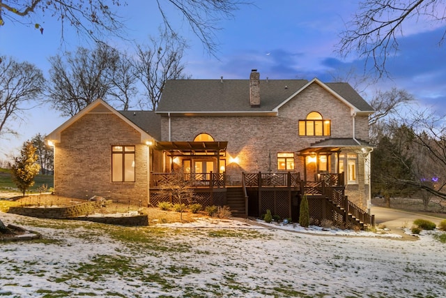 snow covered property with a deck