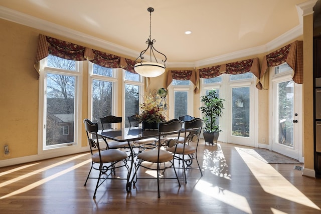 dining area featuring ornamental molding and plenty of natural light