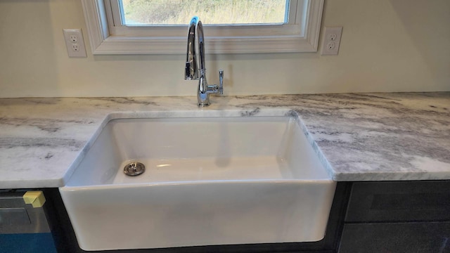 room details featuring light stone countertops and sink