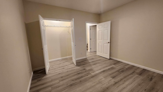 unfurnished bedroom with a closet and light hardwood / wood-style flooring