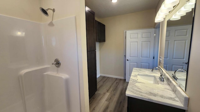 bathroom featuring a shower, a textured ceiling, vanity, and hardwood / wood-style floors