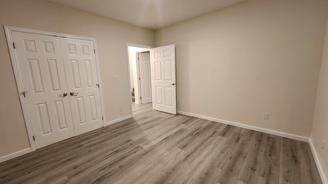 unfurnished bedroom with hardwood / wood-style flooring and a closet