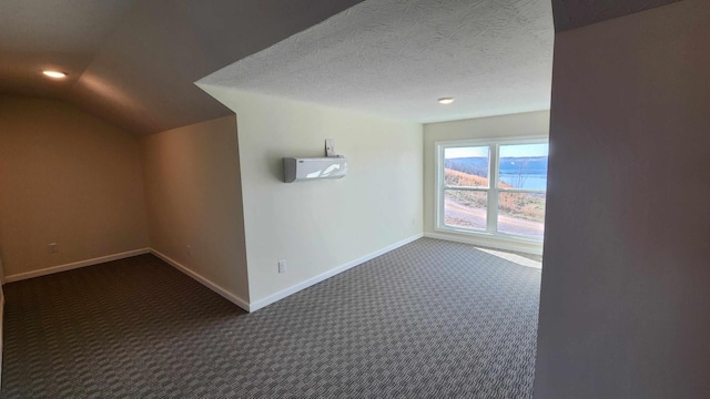 bonus room with a textured ceiling and dark colored carpet