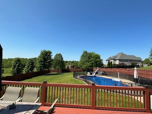 view of swimming pool featuring a wooden deck and a yard