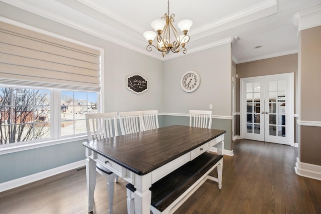 dining area with dark wood-type flooring, french doors, crown molding, and a chandelier