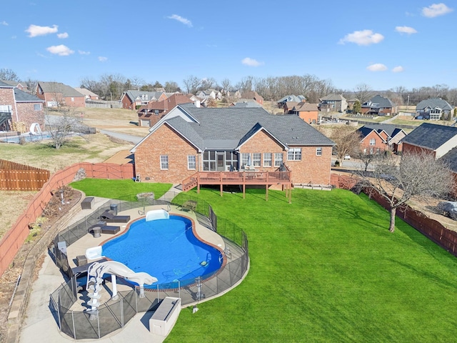 view of pool with a wooden deck and a lawn