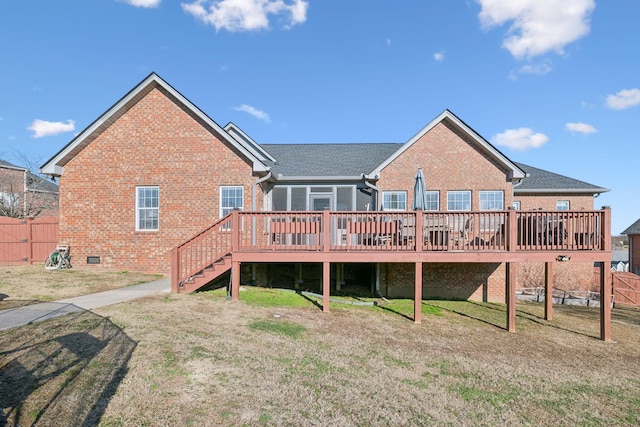 rear view of house with a wooden deck and a lawn