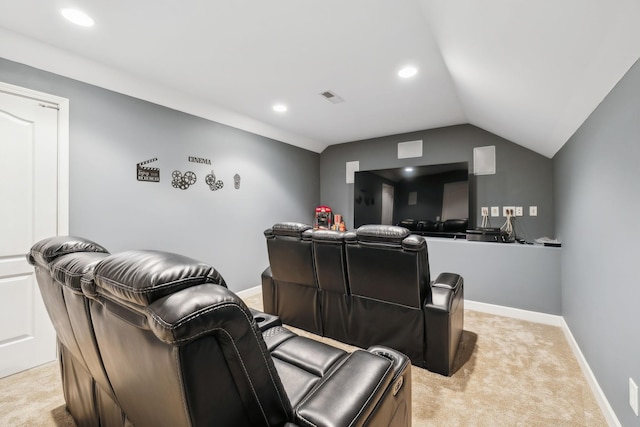 home theater room with lofted ceiling and light colored carpet