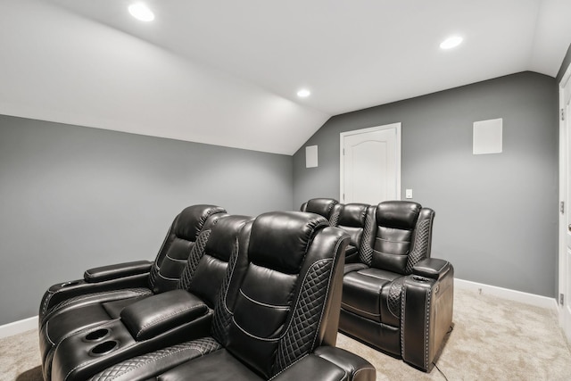 home theater room featuring light carpet and vaulted ceiling