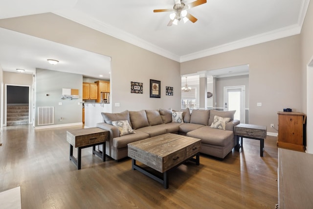 living room featuring dark hardwood / wood-style flooring, ceiling fan with notable chandelier, and ornamental molding