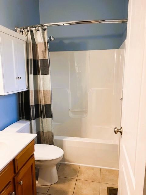 full bathroom with toilet, vanity, tile patterned flooring, and shower / bath combination with curtain