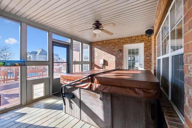 sunroom / solarium featuring ceiling fan and a hot tub