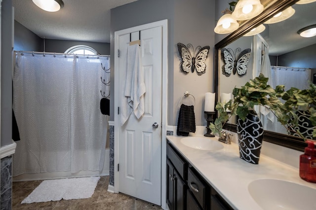 bathroom featuring vanity, shower / bath combo, and a textured ceiling