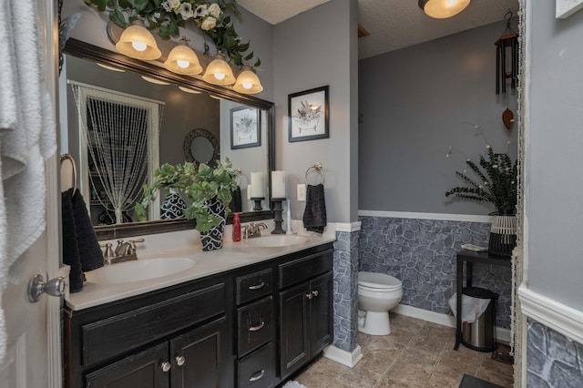 bathroom with a textured ceiling, toilet, and vanity