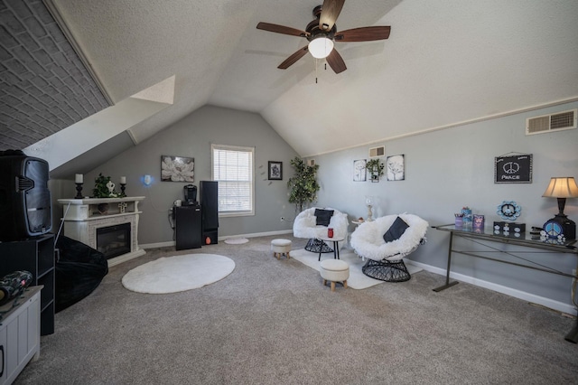 carpeted living room with a textured ceiling, ceiling fan, and vaulted ceiling