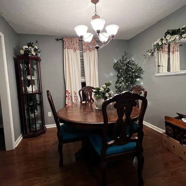 dining room featuring a textured ceiling, a notable chandelier, and dark hardwood / wood-style flooring