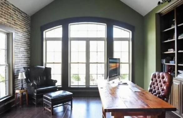 office area with brick wall, lofted ceiling, and dark hardwood / wood-style flooring