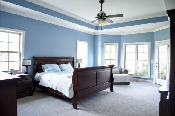 carpeted bedroom featuring crown molding, a raised ceiling, and ceiling fan