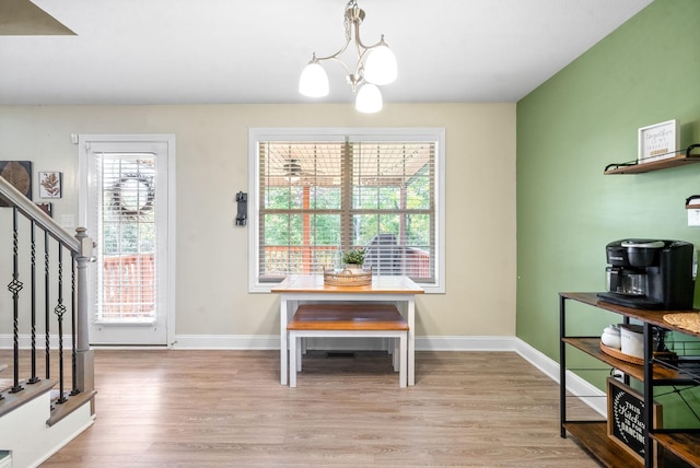 dining space with a wealth of natural light, a chandelier, and light wood-type flooring