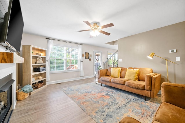 living room featuring light wood-type flooring and ceiling fan