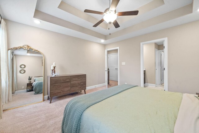 carpeted bedroom featuring a tray ceiling, ceiling fan, and a closet