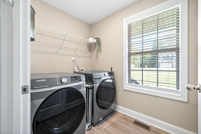 laundry room with hardwood / wood-style flooring and washer and dryer