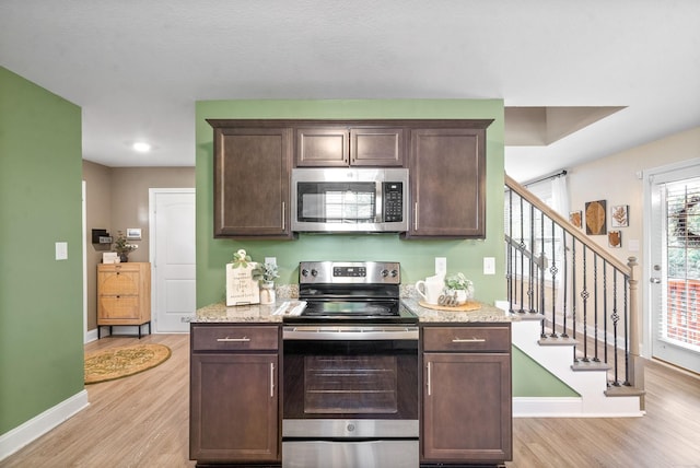 kitchen featuring dark brown cabinets, stainless steel appliances, and plenty of natural light