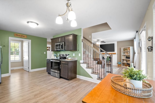 kitchen featuring ceiling fan with notable chandelier, light hardwood / wood-style flooring, decorative light fixtures, dark brown cabinetry, and stainless steel appliances